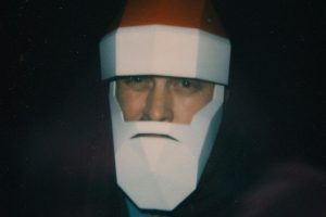 Ein Mann mit Weihnachtsmannplastikmaske